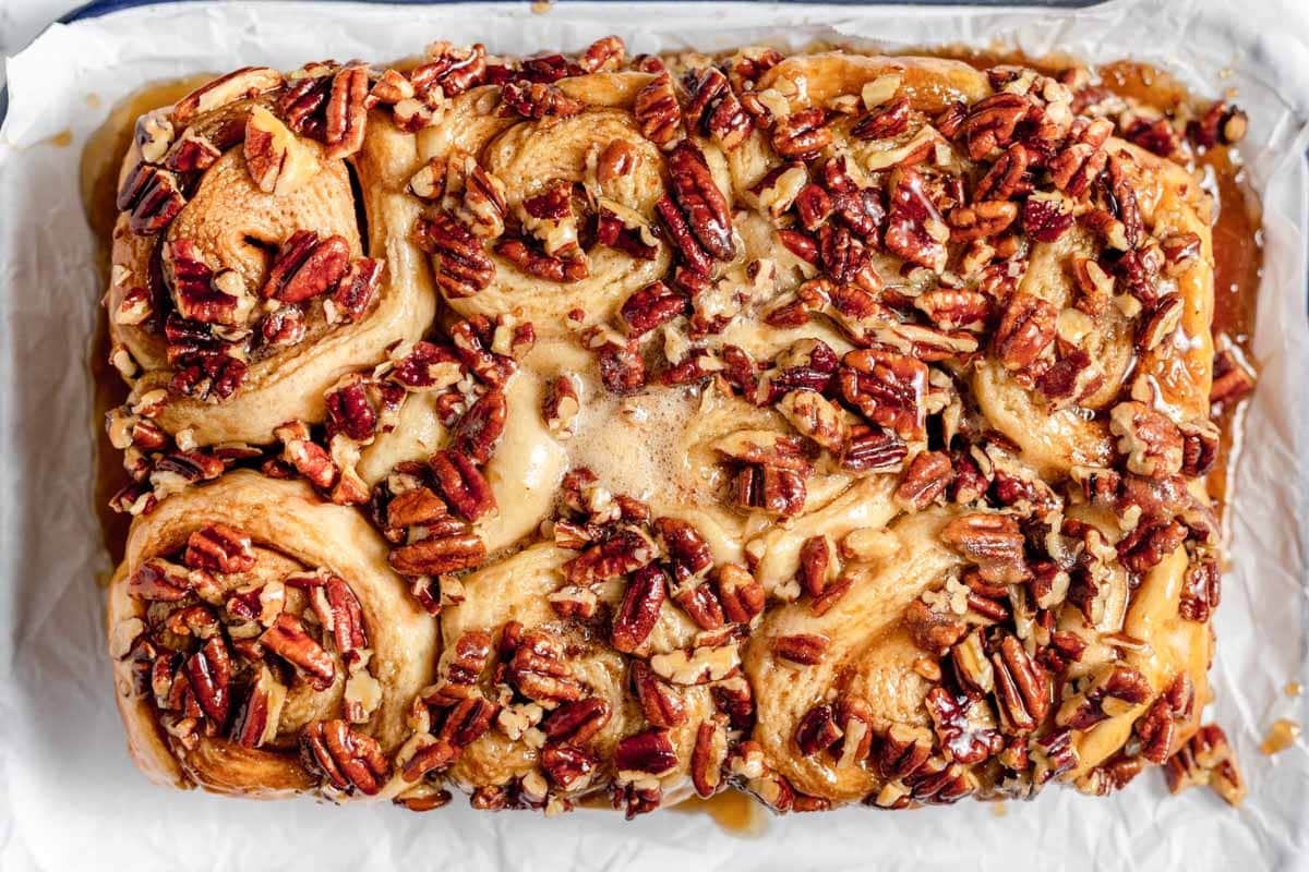Pecan rolls with pecans on a baking sheet.
