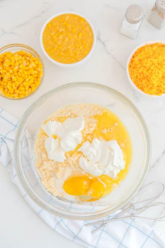 A bowl with eggs, corn, and other ingredients.