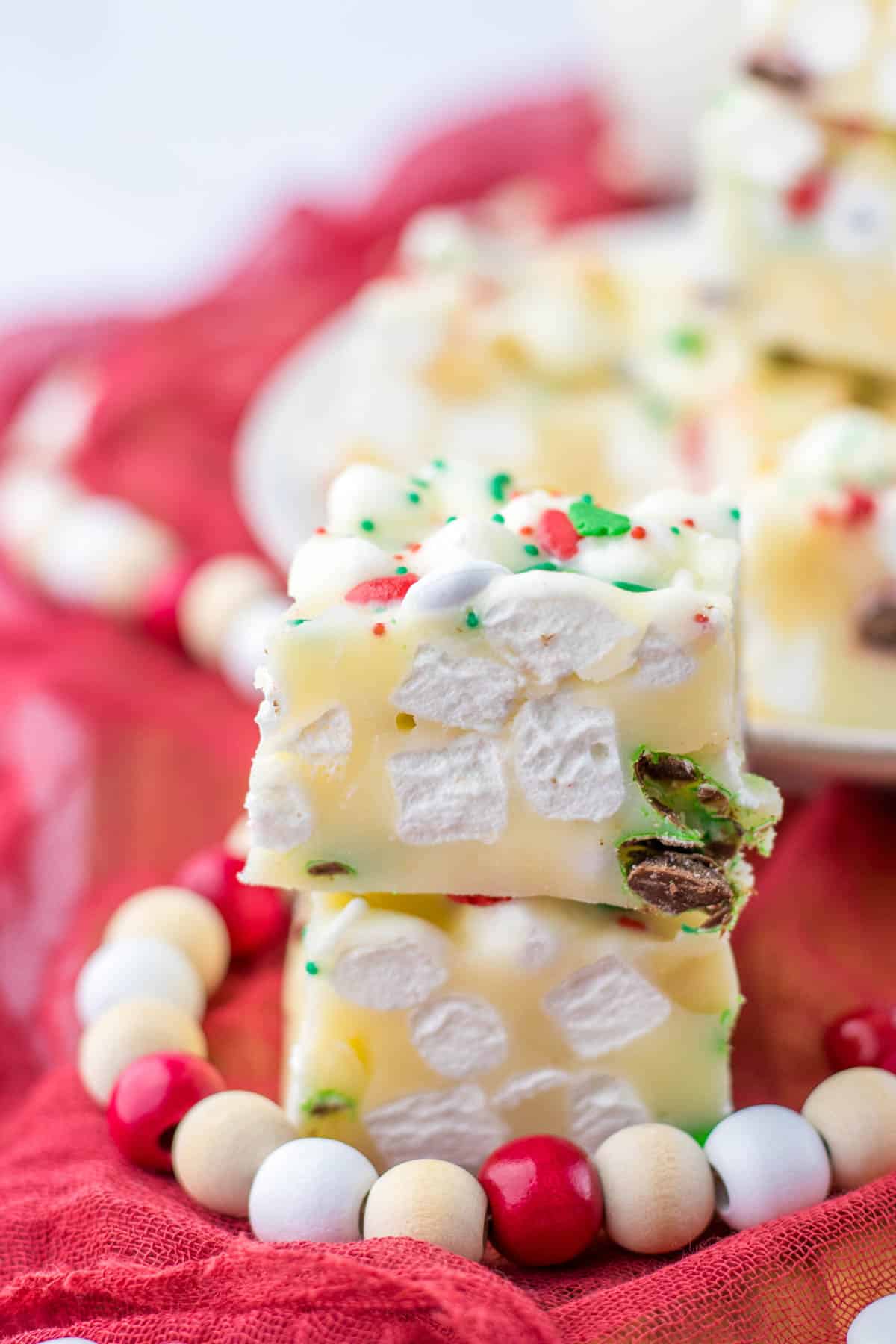 A stack of white chocolate rocky road on a red cloth.