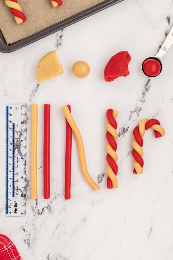 A set of candy canes and a ruler on a marble table.