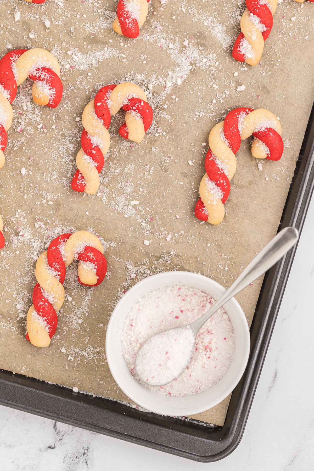 Candy cane cookies on a baking sheet.