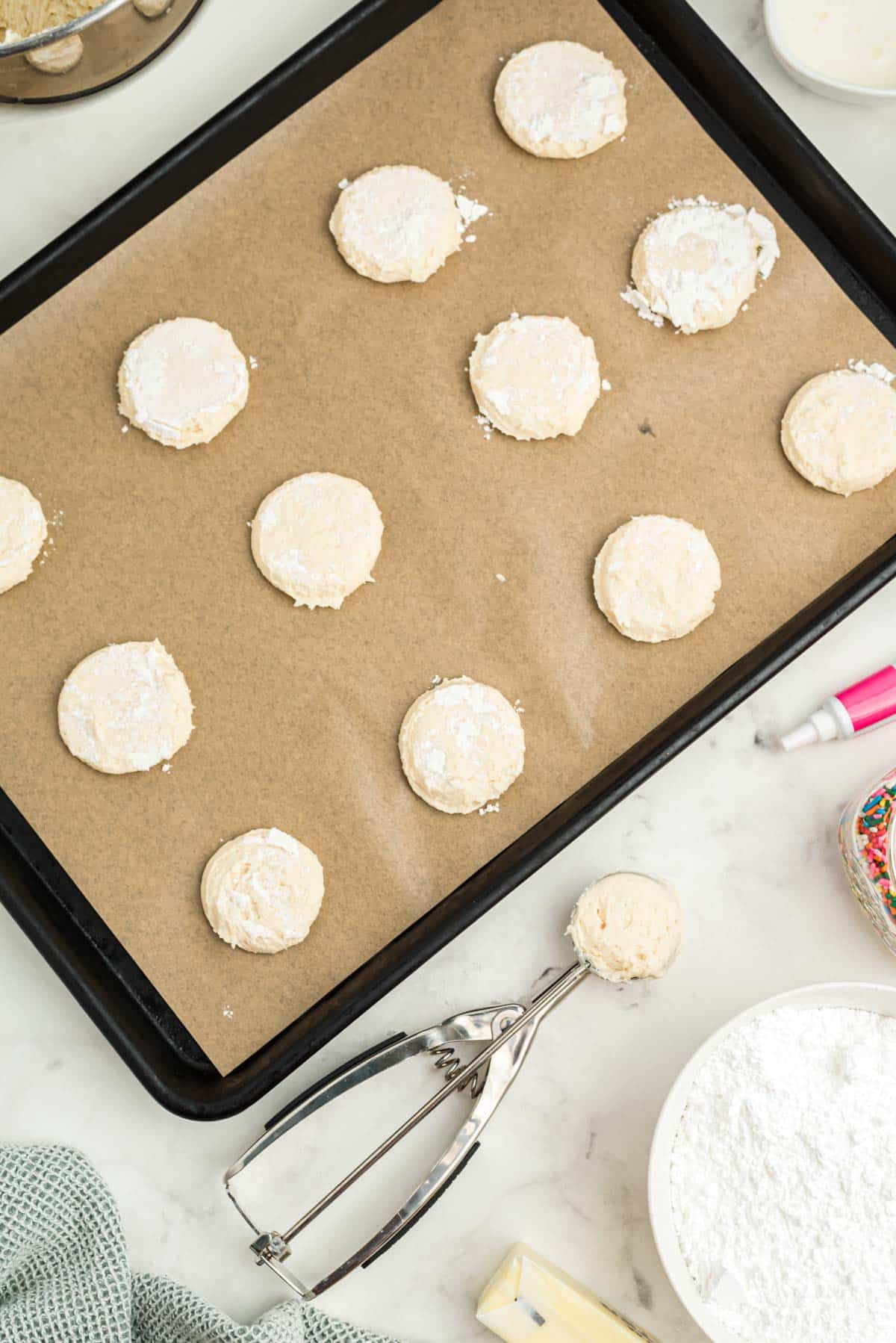 A baking sheet with cookies and ingredients on it.