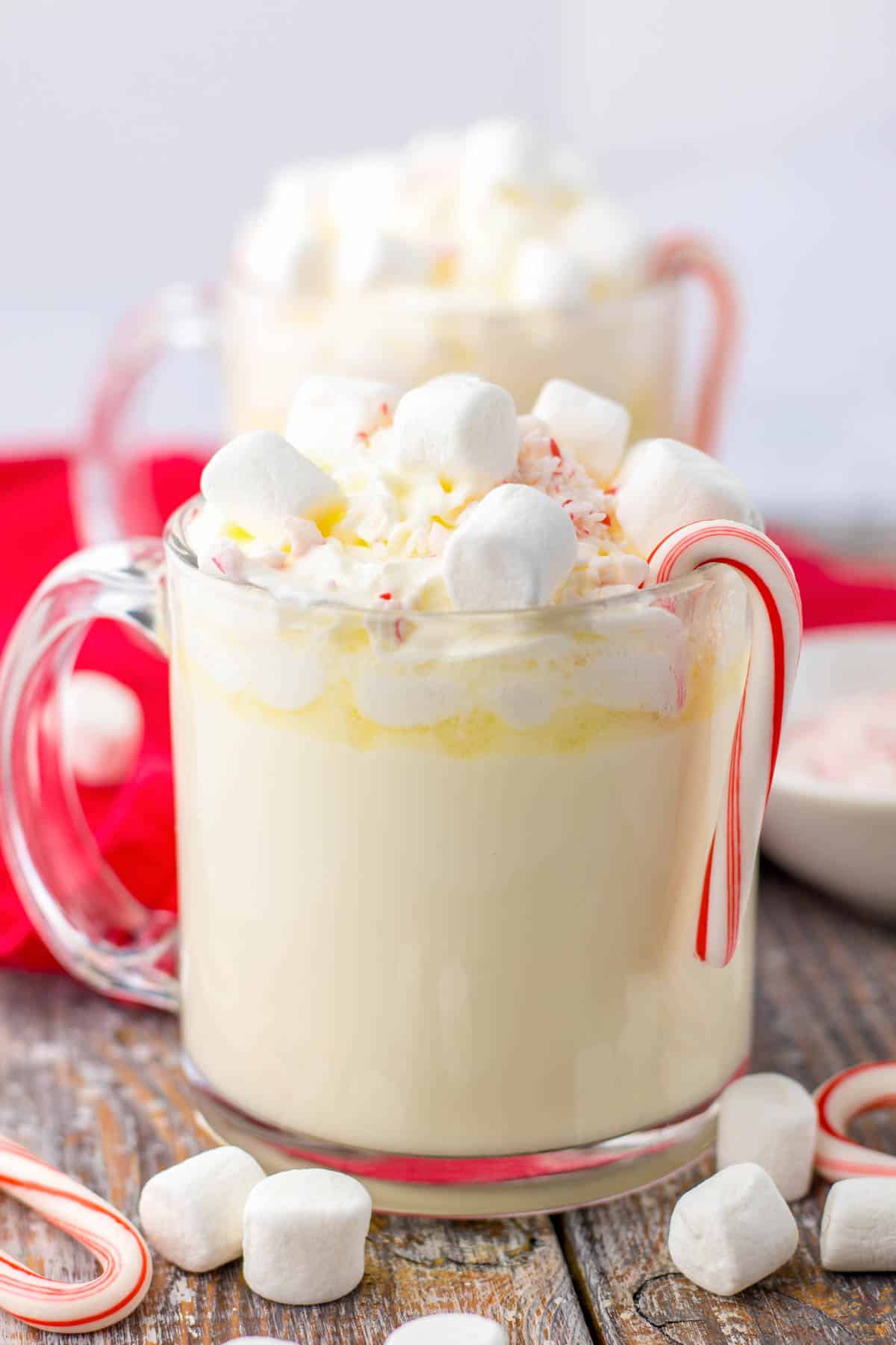 Two cups of hot chocolate with marshmallows and candy canes.