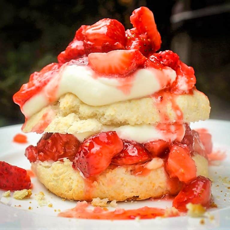 A white plate with a strawberry scone on it.