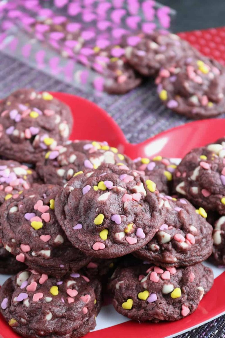 Valentine's day cookies with sprinkles on a red plate.