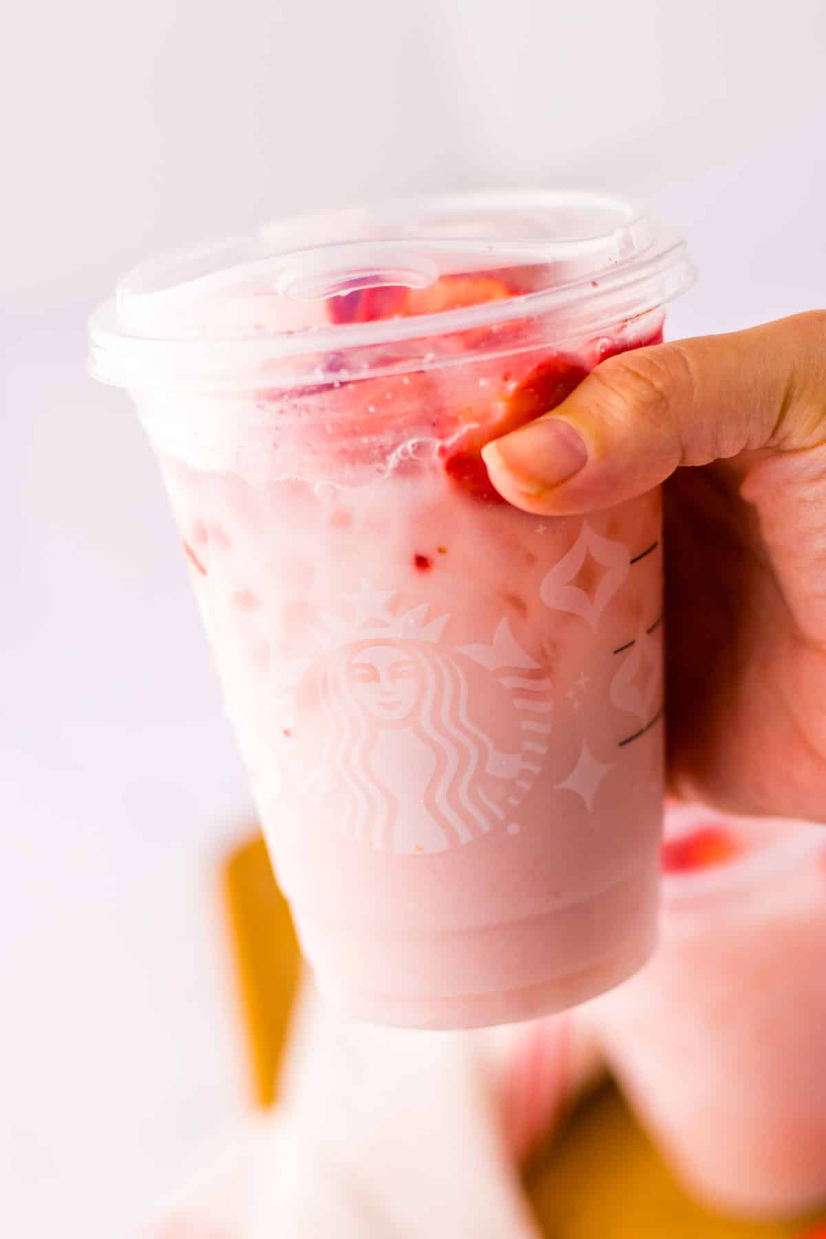 A person holding a cup of Copycat Starbucks Pink Drink.