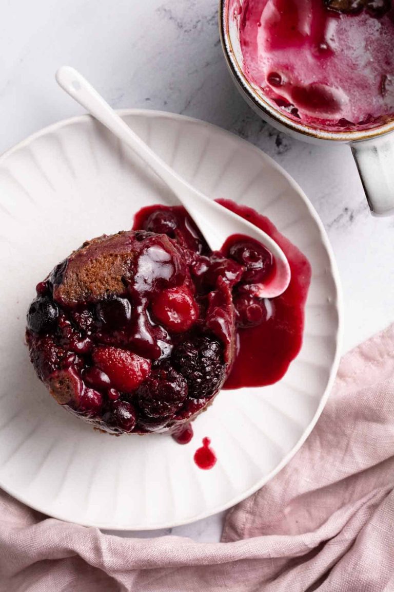 A cake with berries and sauce on a plate.