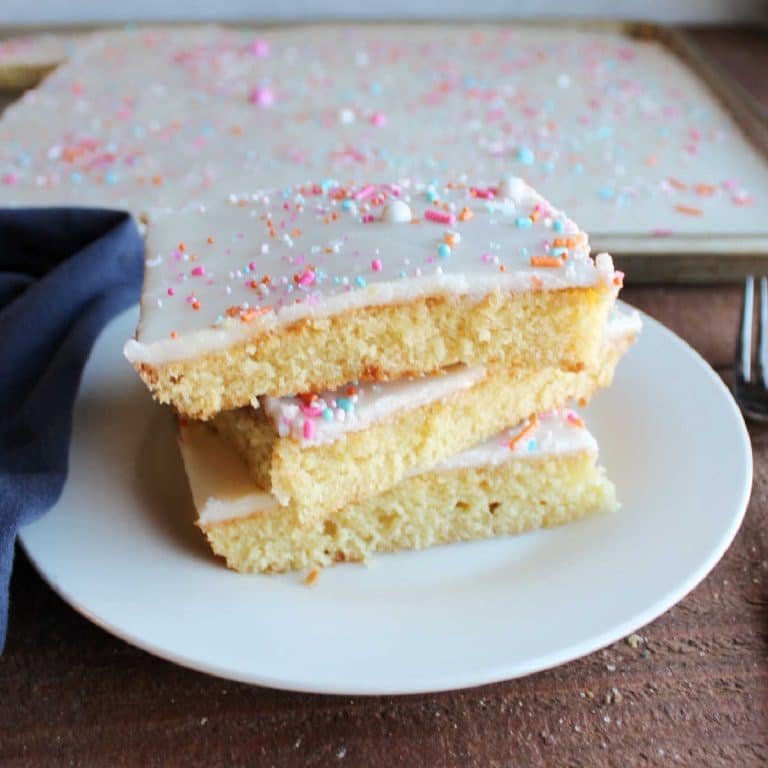 A stack of white cake bars with sprinkles on a plate.