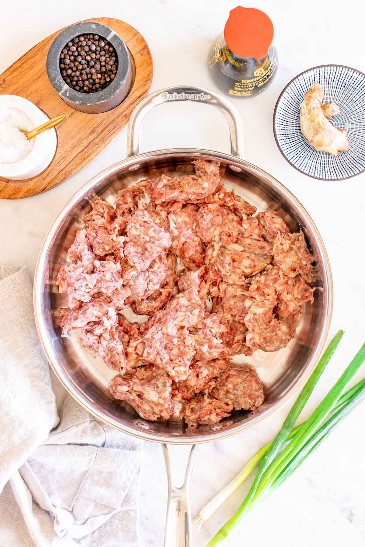 A frying pan with meat, onions and other ingredients.