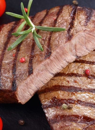 Best way to reheat a grilled steak with tomatoes and spices on a black background.