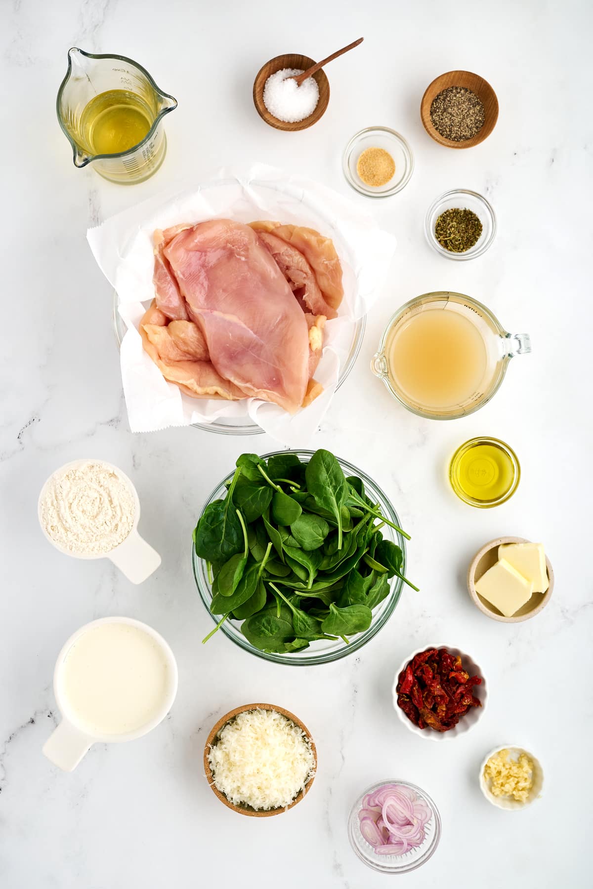 Ingredients for chicken florentine include boneless and skinless chicken breasts, kosher salt, black pepper, garlic powder, Italian seasoning, all-purpose flour, extra virgin olive oil, butter, fresh garlic cloves, shallots, dry white wine, chicken broth, heavy cream, freshly grated parmesan cheese, fresh baby spinach leaves, and sliced sun-dried tomatoes.