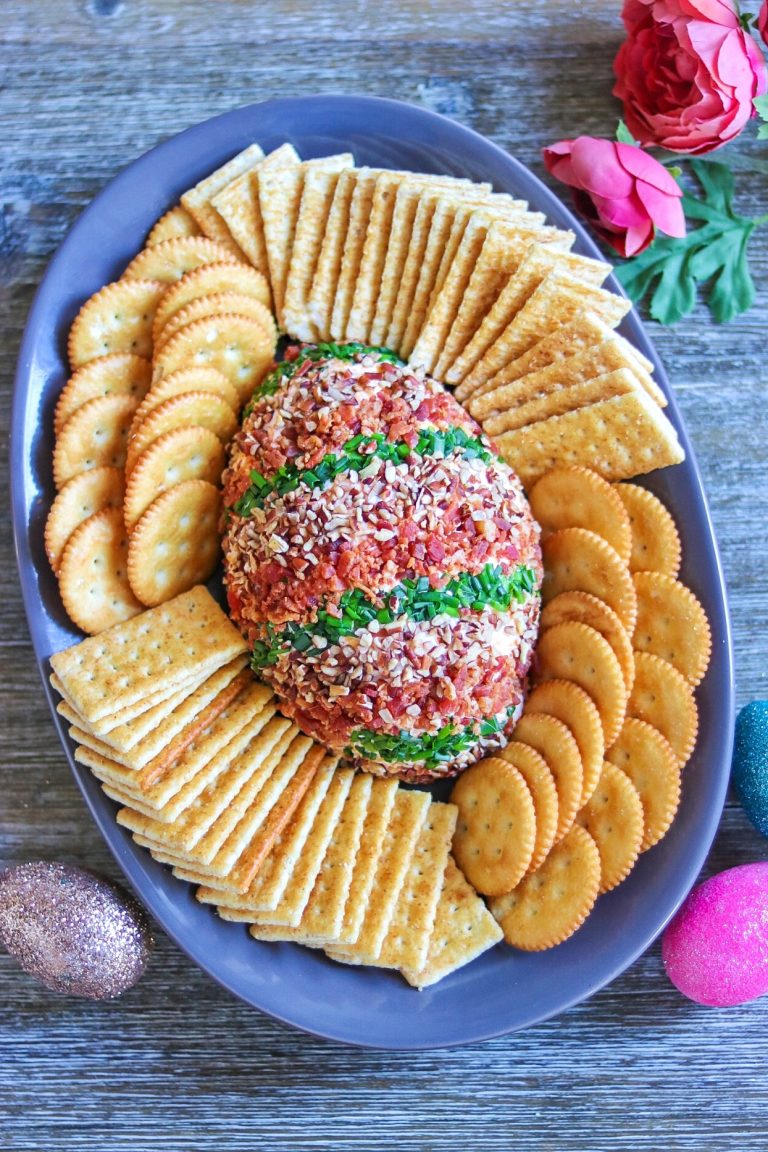 A plate with crackers and a cheese ball on it.