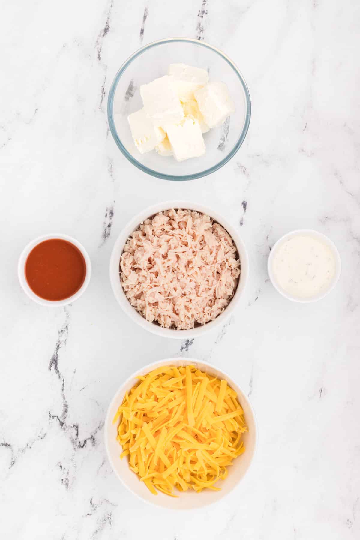 The ingredients for a cheesy rice dish on a marble countertop.