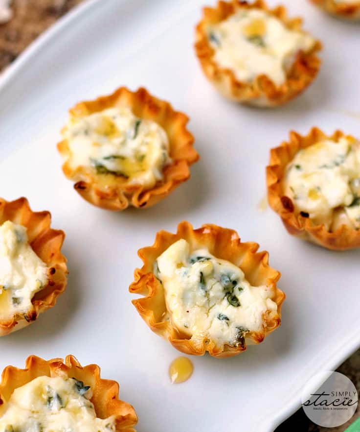 Cheesy spinach tartlets on a white plate.