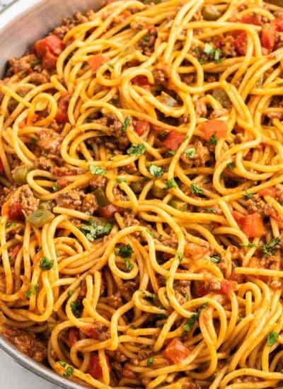 A pan full of taco spaghetti with meat and tomatoes.