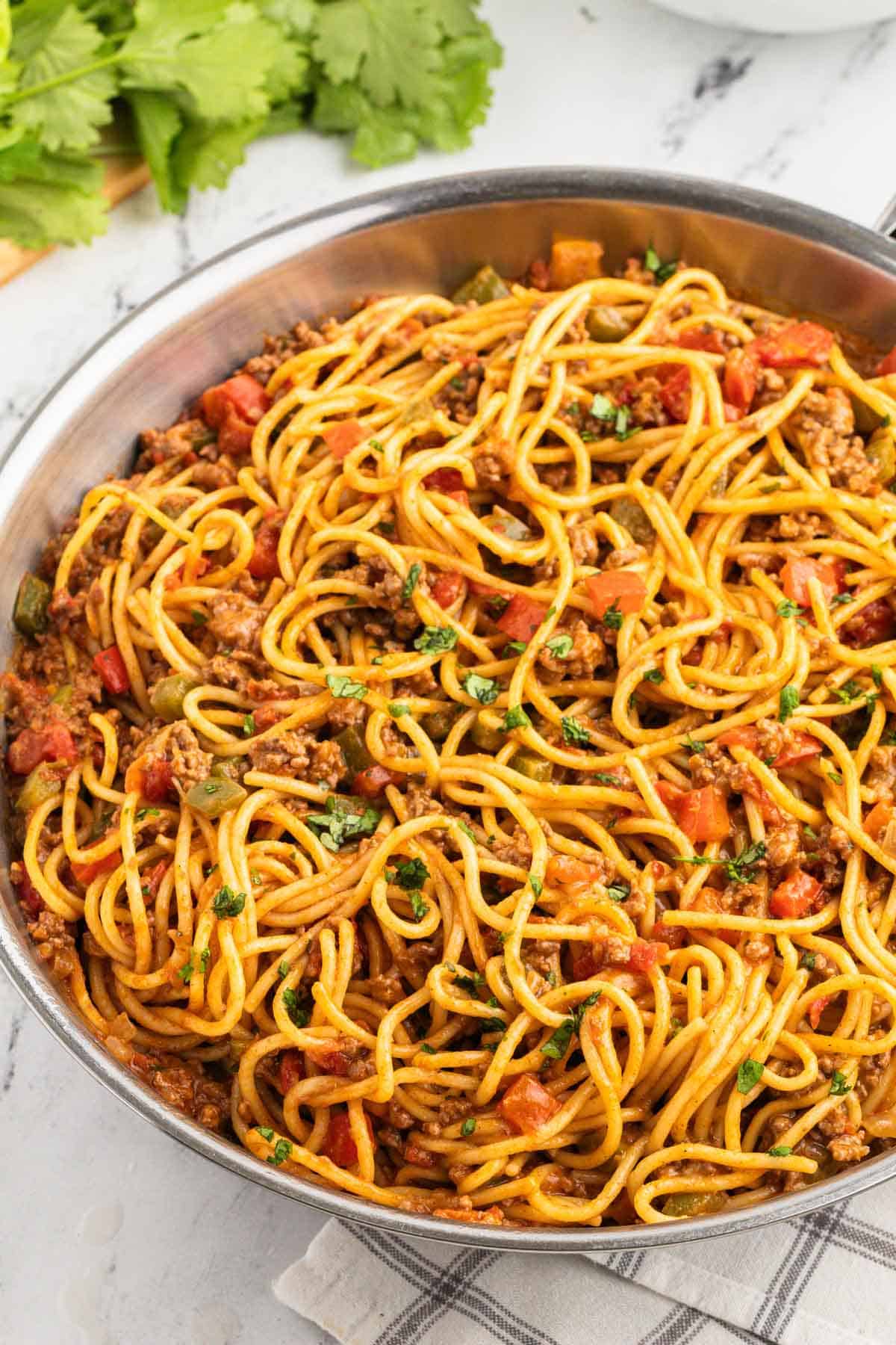 A pan full of spaghetti with meat and vegetables.