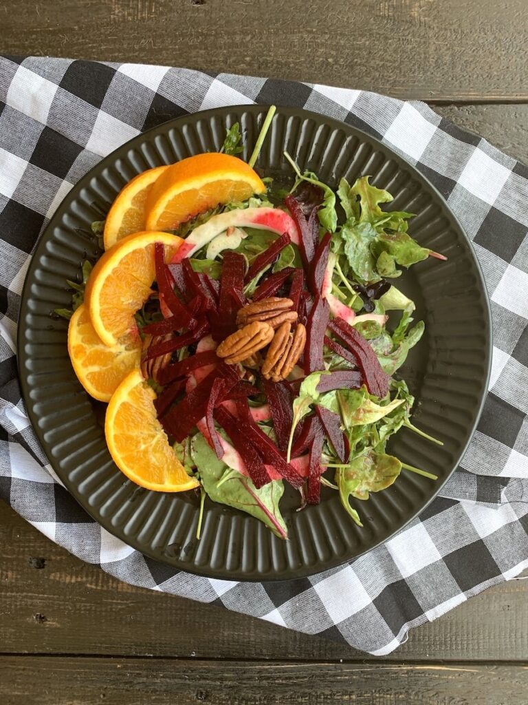 A salad with beets and orange slices on a plate.