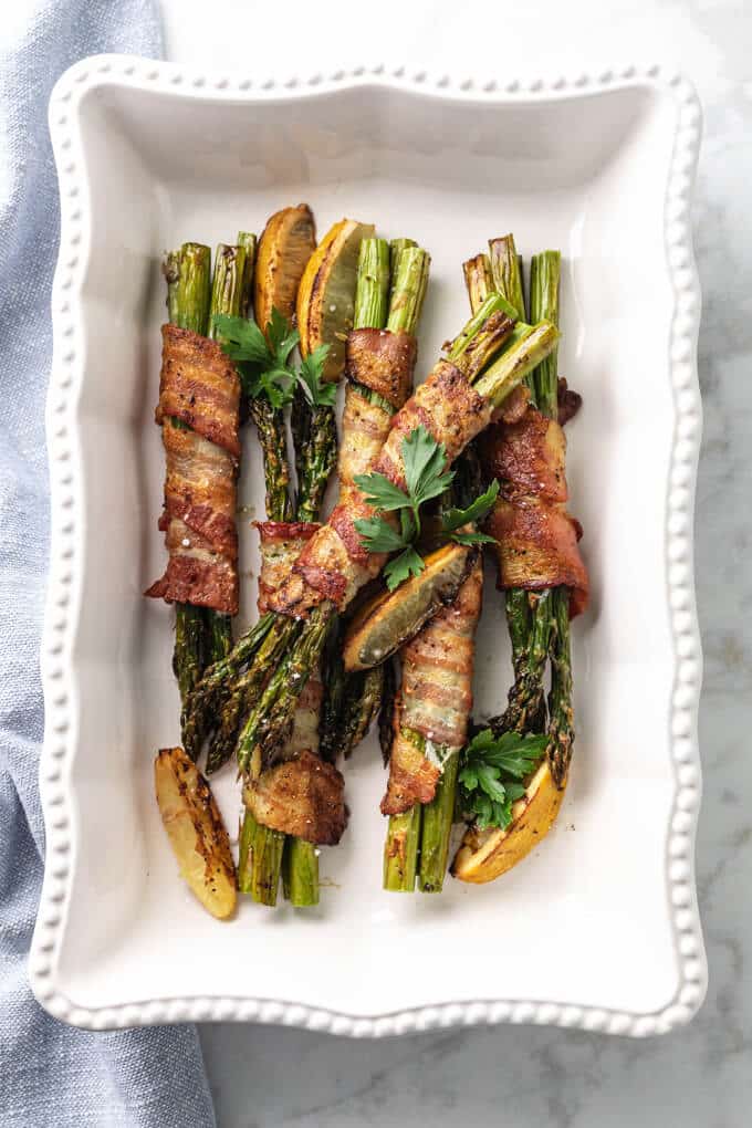 Bacon wrapped asparagus on a white plate.
