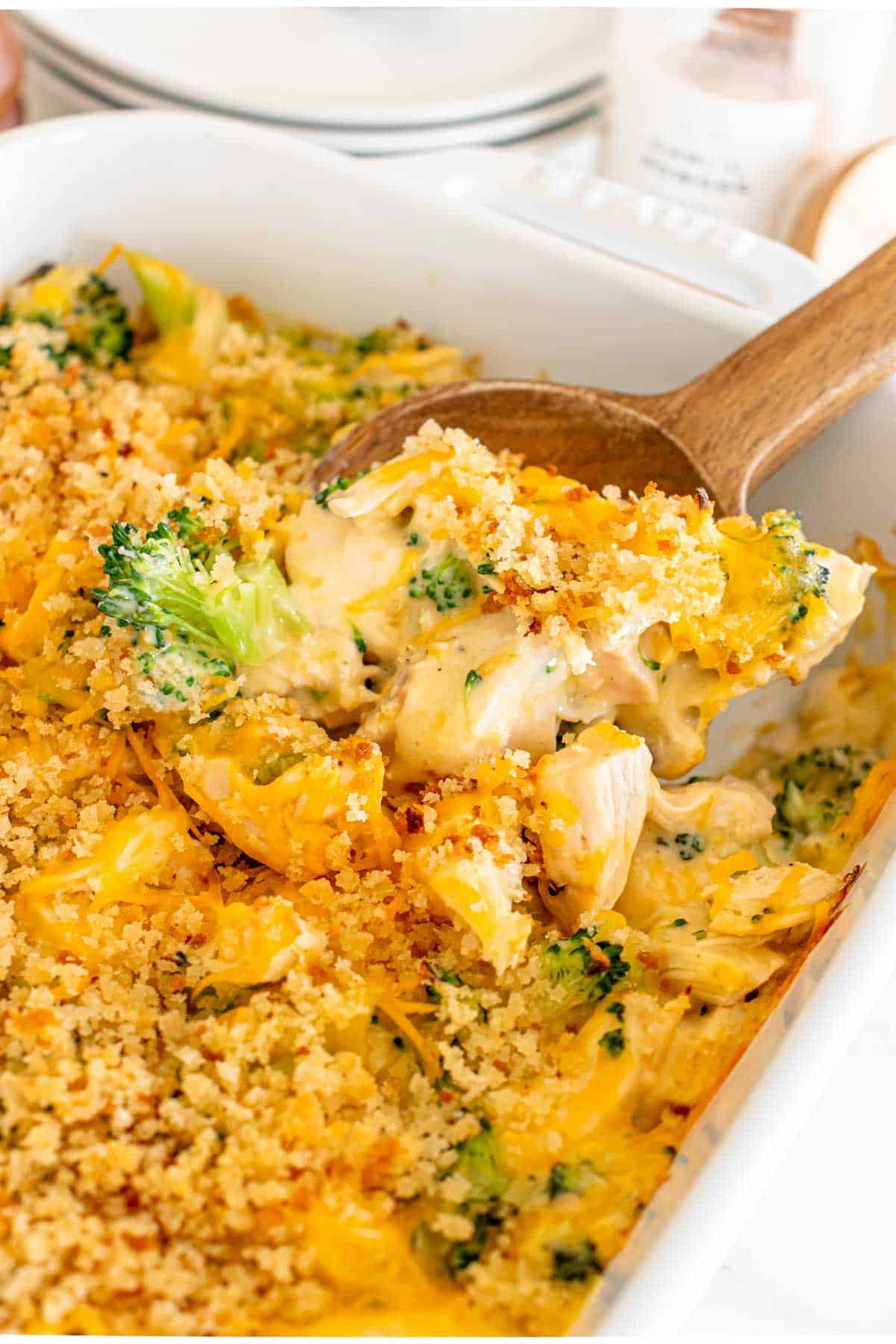 Chicken Divan - A dish of broccoli and cheese casserole with a wooden spoon.
