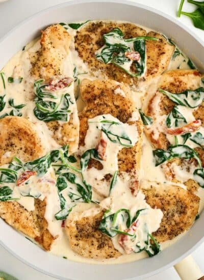 Chicken with spinach and cream sauce in a skillet.