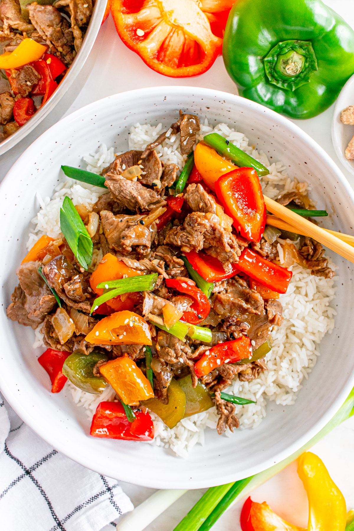 Beef stir-fry with peppers and onions served over white rice.