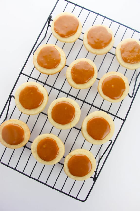 Putting caramel on top of dough is one process in preparing Chocolate Caramel Shortbread Cookies