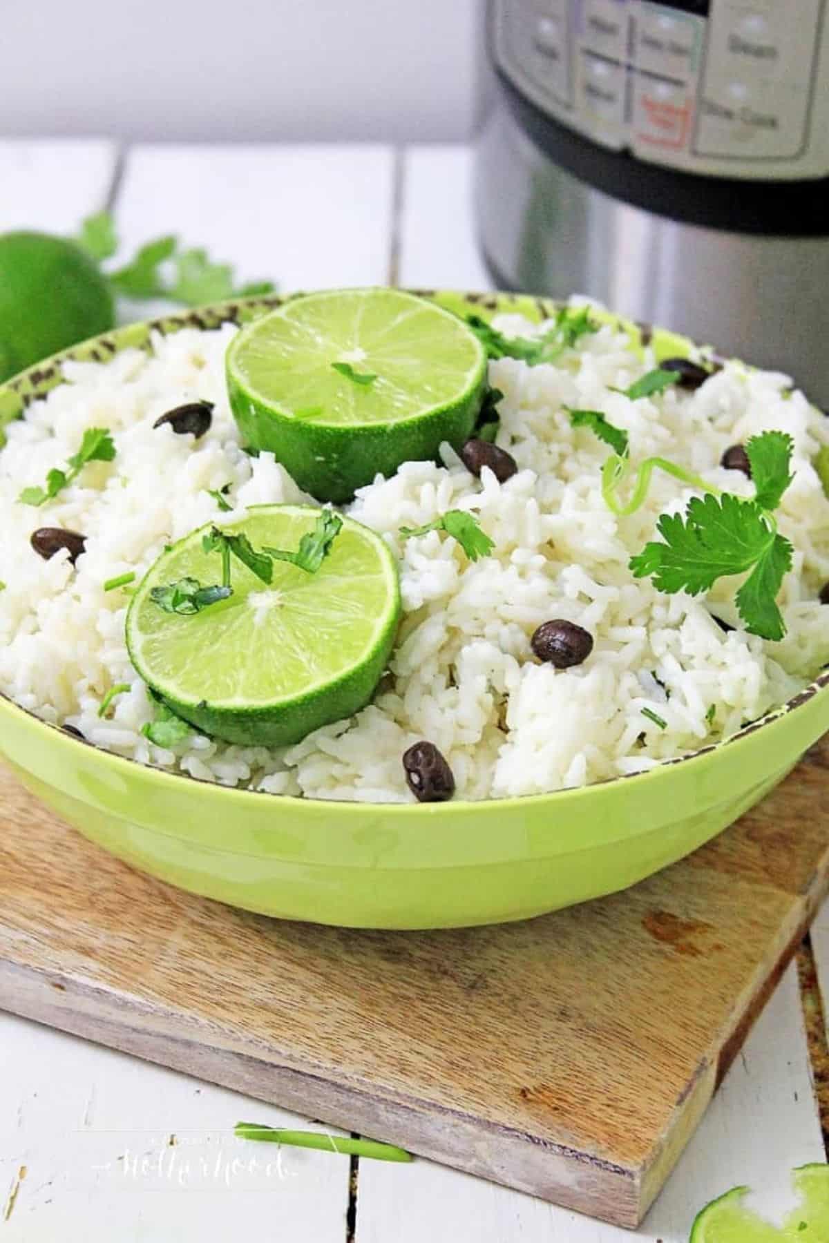 A guide on how to reheat a bowl of cilantro lime rice with black beans garnished with lime wedges on a wooden cutting board.
