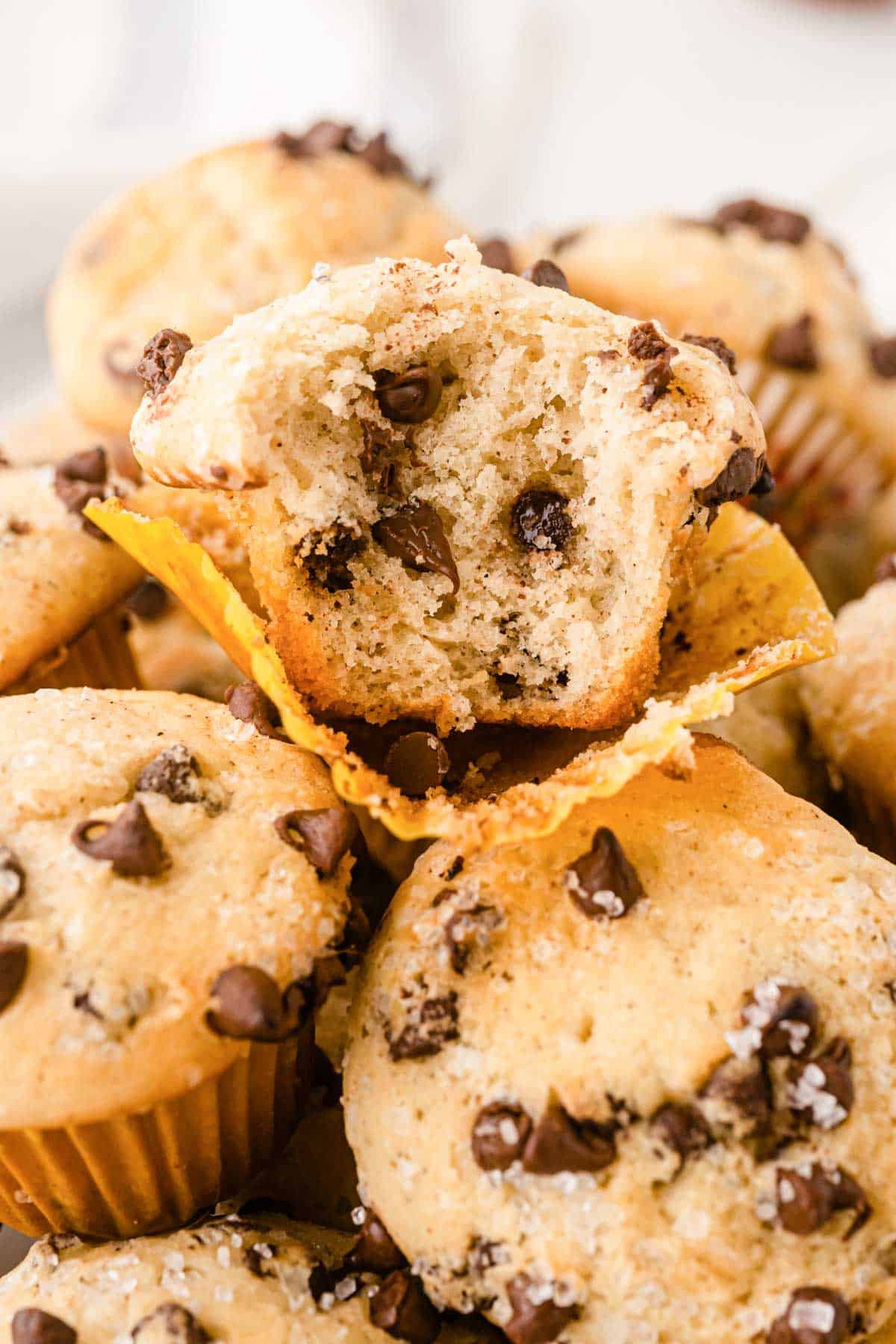 Chocolate chip muffins with a bite taken out of them.