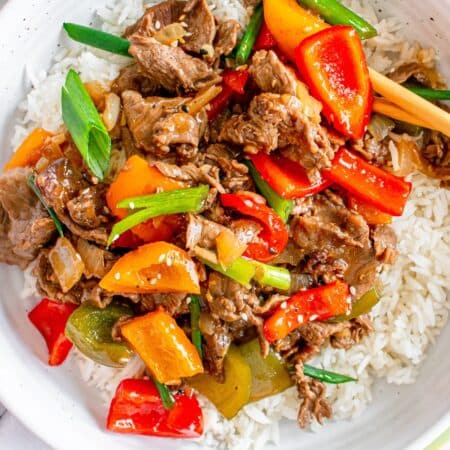 Chinese-style pepper steak with bell peppers and onions served over white rice.