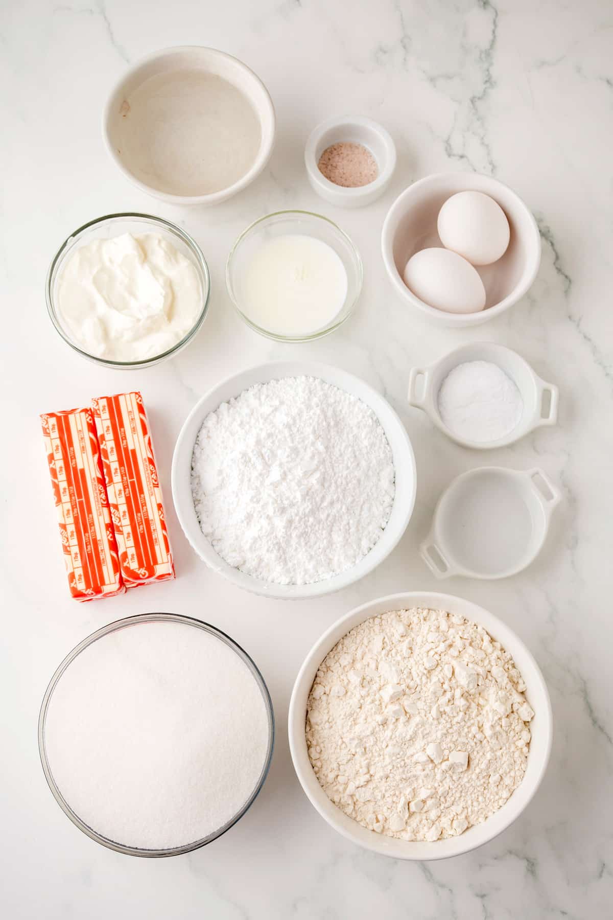 Ingredients for White Texas Sheet Cake are the following: butter, water, all-purpose flour, granulated sugar, eggs, sour cream, almond extract, salt, baking soday. For the frosting, the ingredients are: butter, milk, confectioners sugar, almond extract, and chopped pecans.