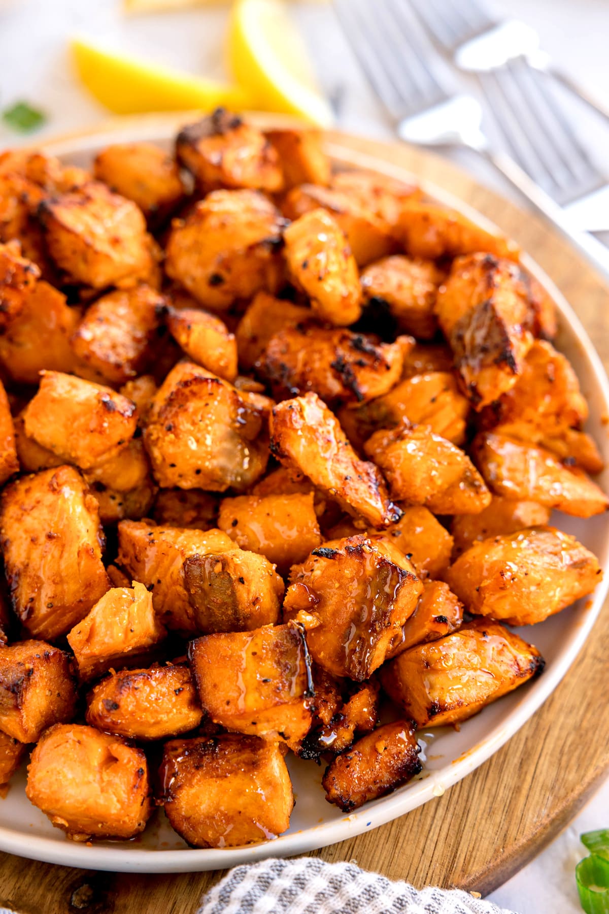 A closer look on a plate of grilled, seasoned Air Fryer Salmon Bites served on a white dish.