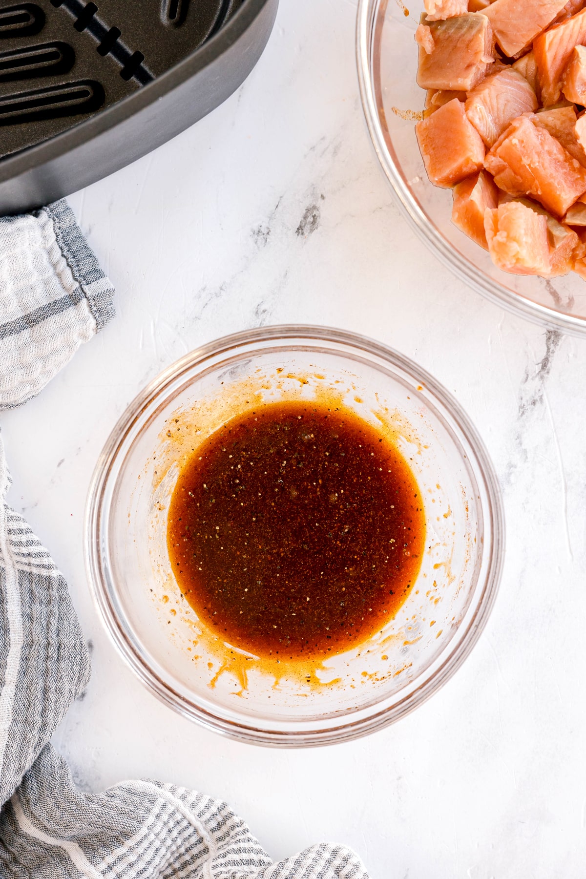 Next step in prepaing Air Fryer Salmon Bites in a small bowl, whisk together the olive oil, soy sauce, honey, paprika, garlic powder, onion powder, salt, and pepper.