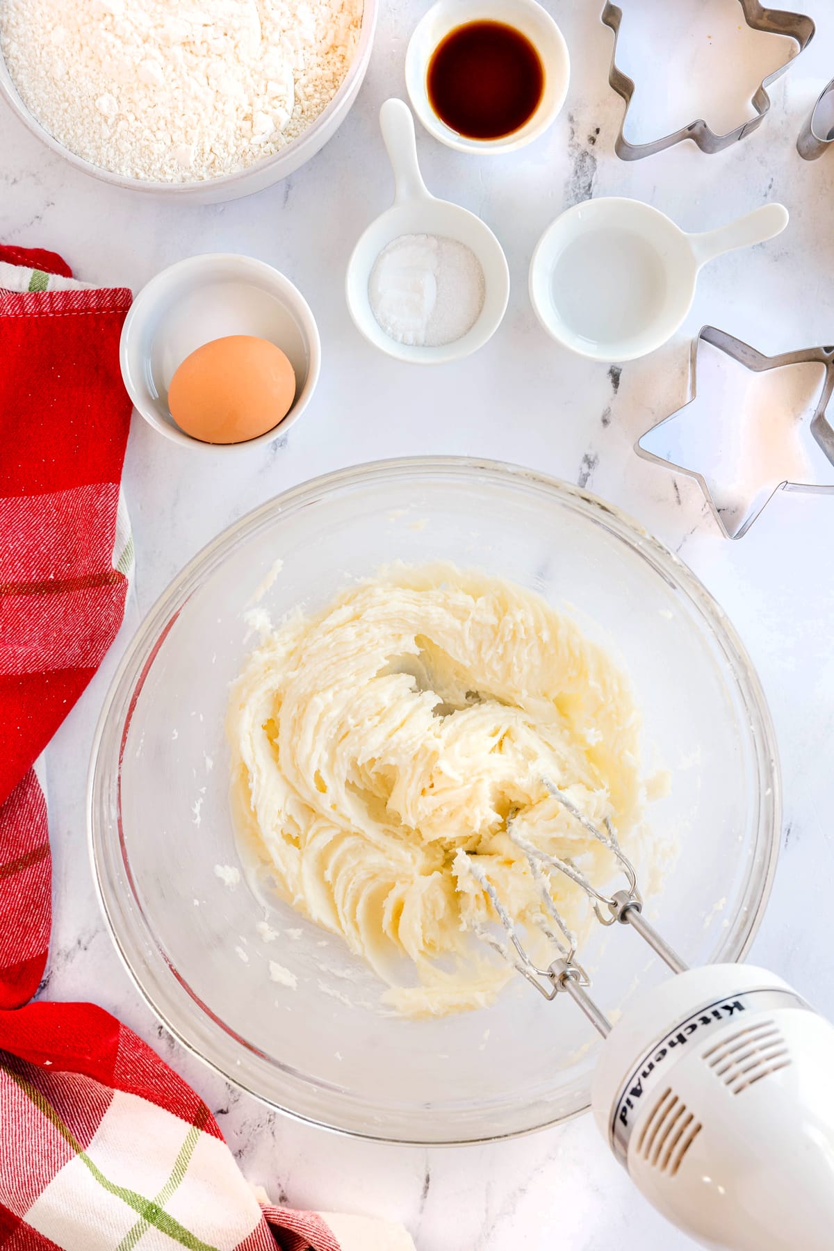 First step in preparing Christmas Sugar Cookies is to add in a mixing bowl a cream cheese, butter and sugar using an electric mixer.