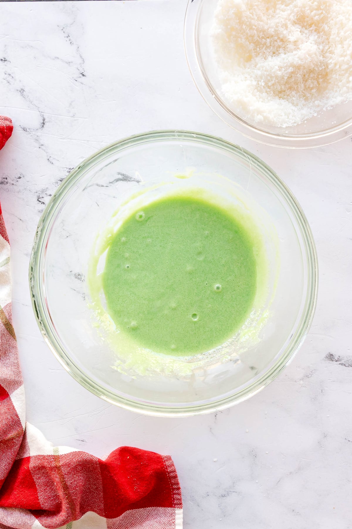 The next process in making Christmas Jello Balls is to prepare the green balls. To do this, combine the green Jello with ½ cup sweetened condensed milk in a separate bowl.