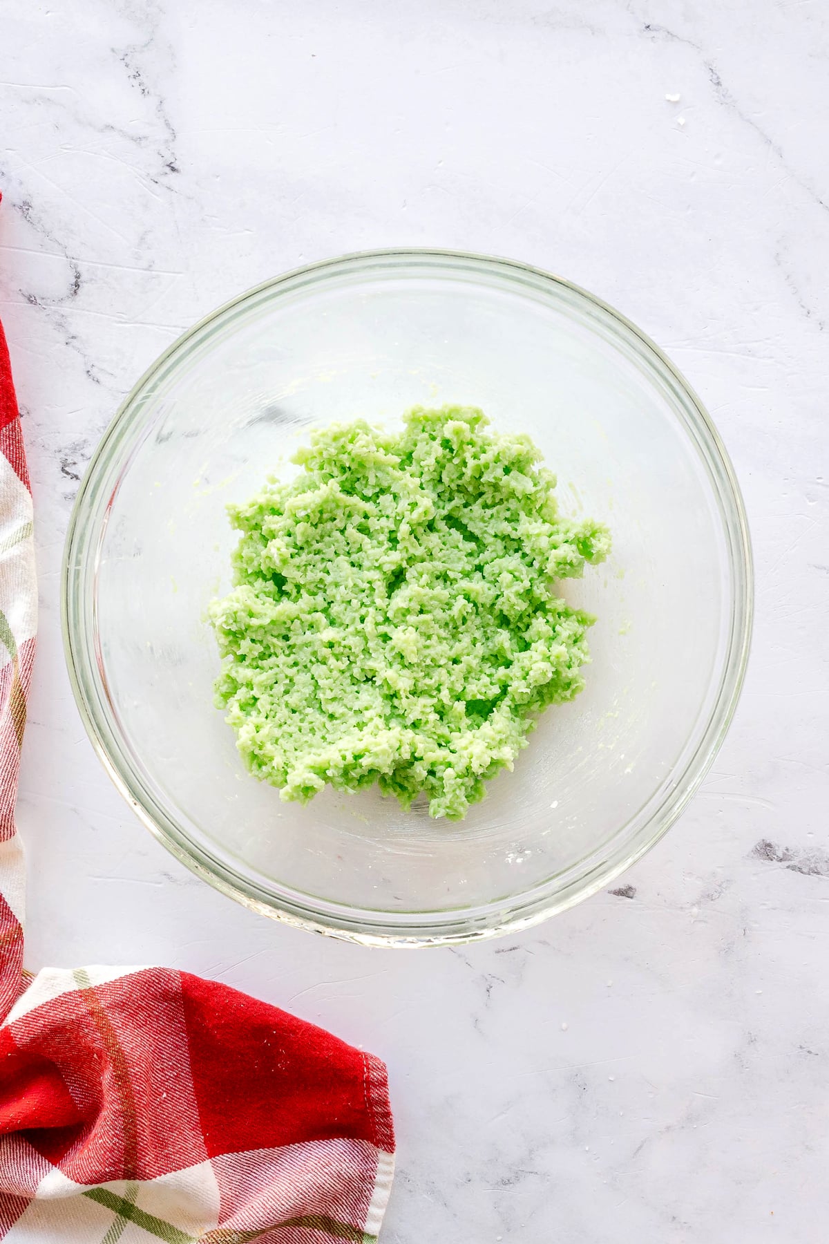 Adding grated coconut on green jello mixture for Christmas Jello Balls.