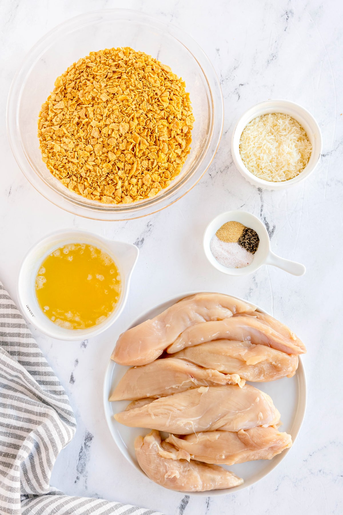 Ingredients for Cornflake Chicken include cornflake cereal, grated parmesan cheese, salt and black pepper, garlic powder, chicken, and unsalted butter.