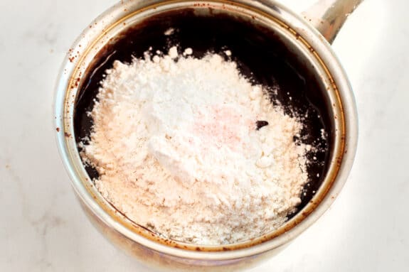A metal saucepan with coffee, flour and salt. One process in preparing Fudgy Brownies