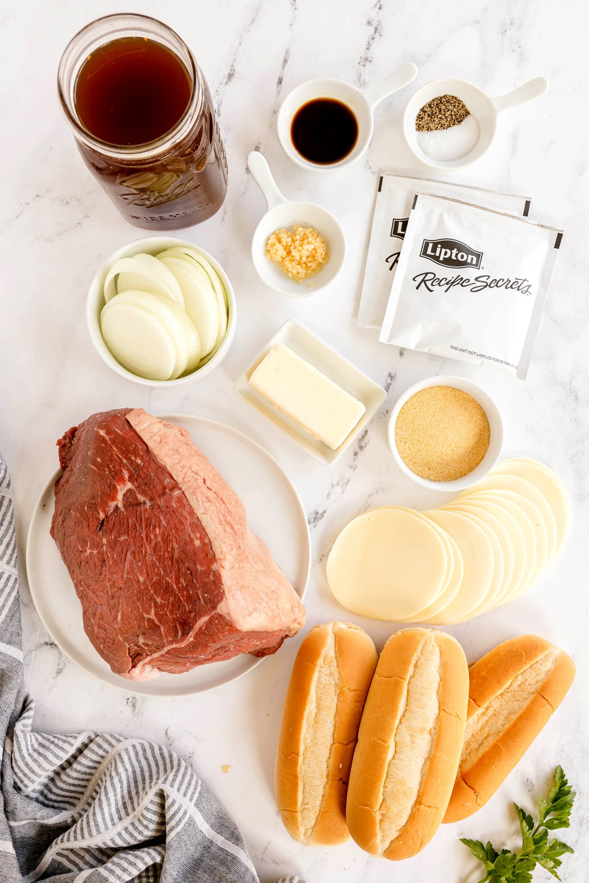 Ingredients for Slow Cooker French Dip Sandwiches include: beef stock, worcestershire sauce, salt, pepper, beefy onion soup mix, onion, garlic, rump roast, sub rolls, butter, garlic powder, and povolone cheese