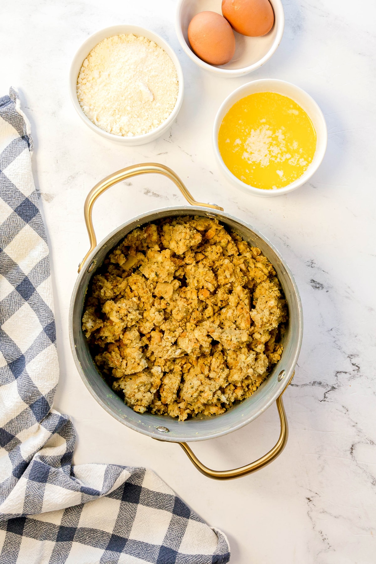 First step in preparing Spinach Balls is to stir in the eggs, Parmesan cheese, and melted butter until fully combined.