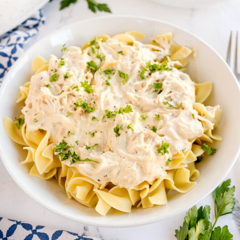 A bowl of Slow Cooker Creamy Italian Chicken with parsley.