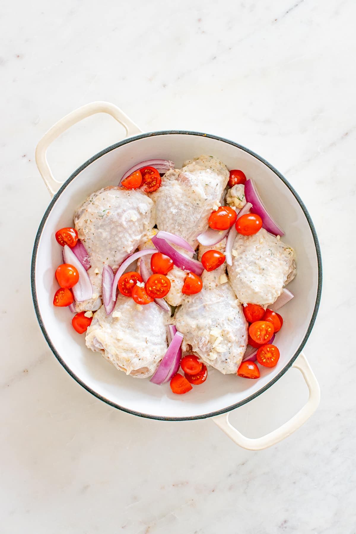 After coating the chicken, arrange the sliced tomatoes and red onion around the drumsticks and drizzle the vegetables with 2 teaspoons of olive oil. This is for One Pan Greek Chicken Drumsticks and bake for 35 minutes