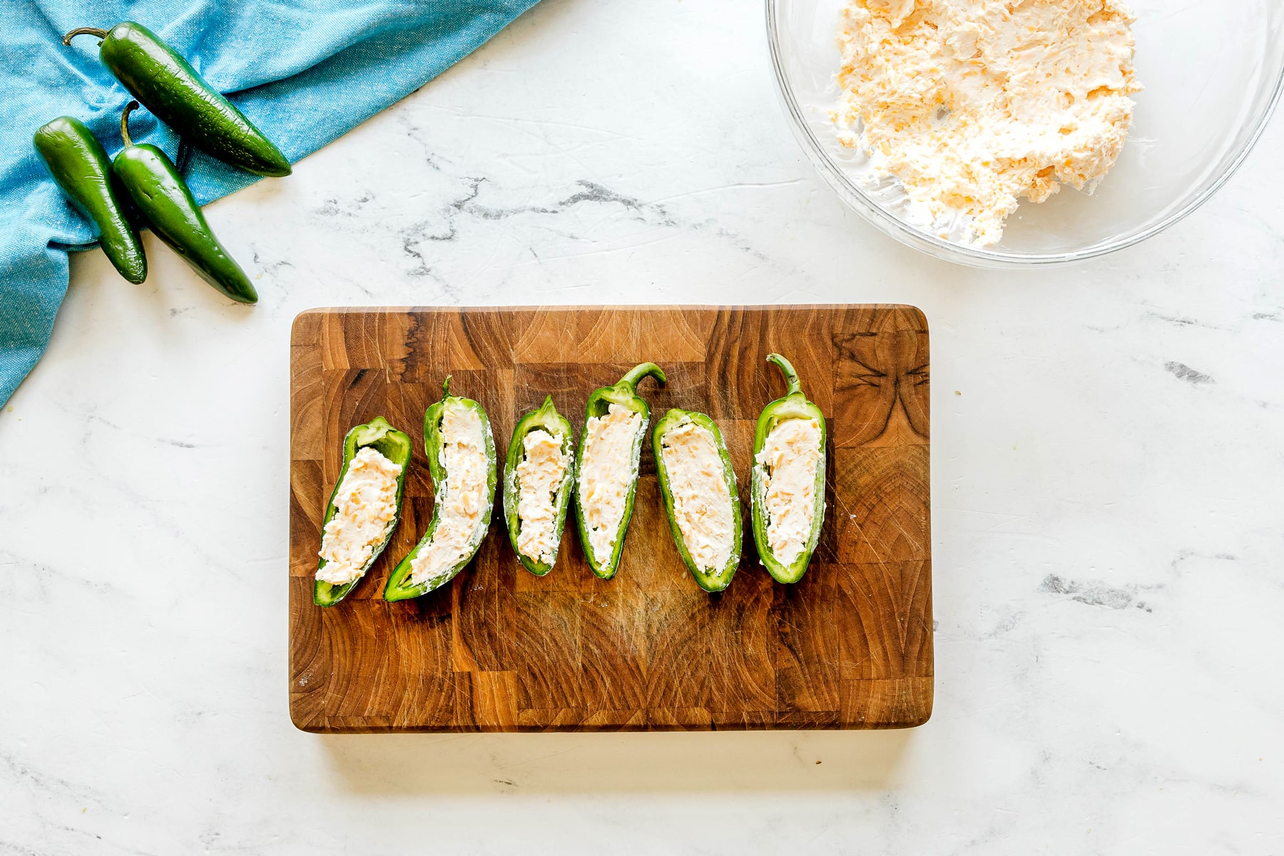 Next step in preparing Jalapeño Poppers Wrapped in Bacon is to fill the peppers with a creamy mixture.