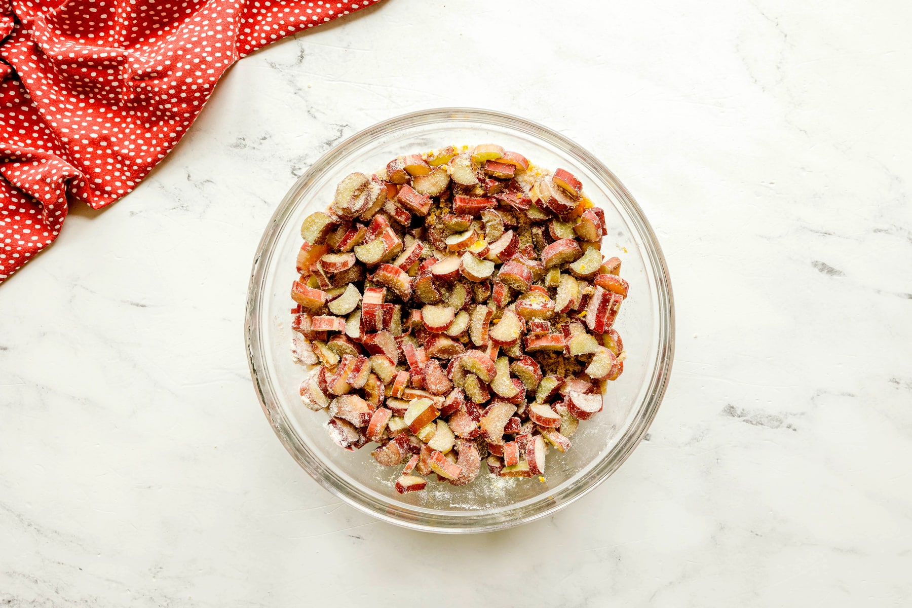To prepare Rhubarb Pie, use a clear glass bowl filled with rhubarb, 1 cup sugar, brown sugar, flour, orange zest, and vanilla and toss until evenly coated.