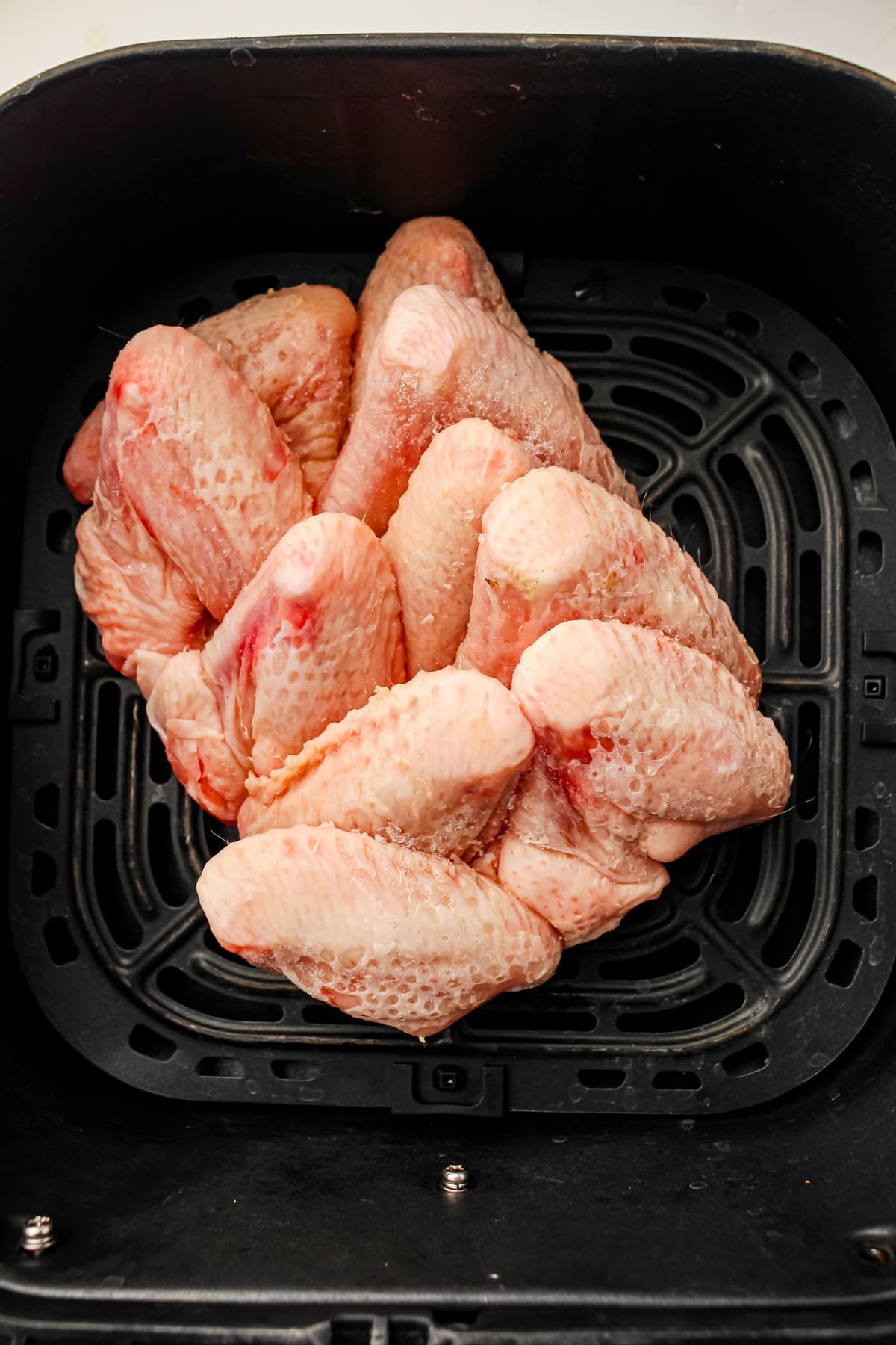First step in preparing Air Fryer Frozen Chicken Wings is to add this on to air fryer basket.