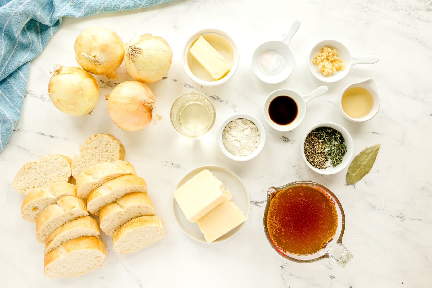 Ingredients for French Onion Soup are the following: yellow onions, butter, salt, beef stock, garlic, white wine, sherry, flour, fresh thyme, bay leaf, pepper, French bread, and Gruyère or Swiss cheese.