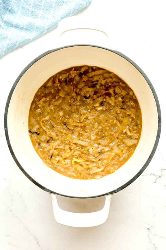 Next step in preparing French Onion Soup is to add garlic, white wine, and sherry to the mixture.
