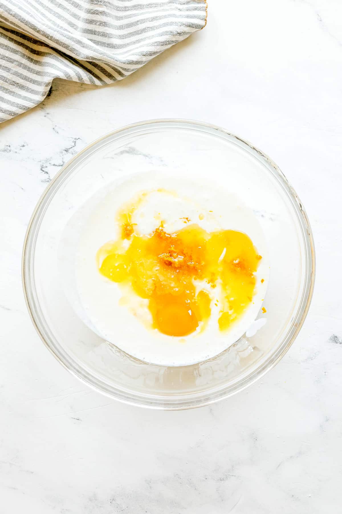 Next step in preparing Irish Soda Bread is to whisk buttermilk, melted butter, egg, and orange zest, and pour it into dry ingredients.