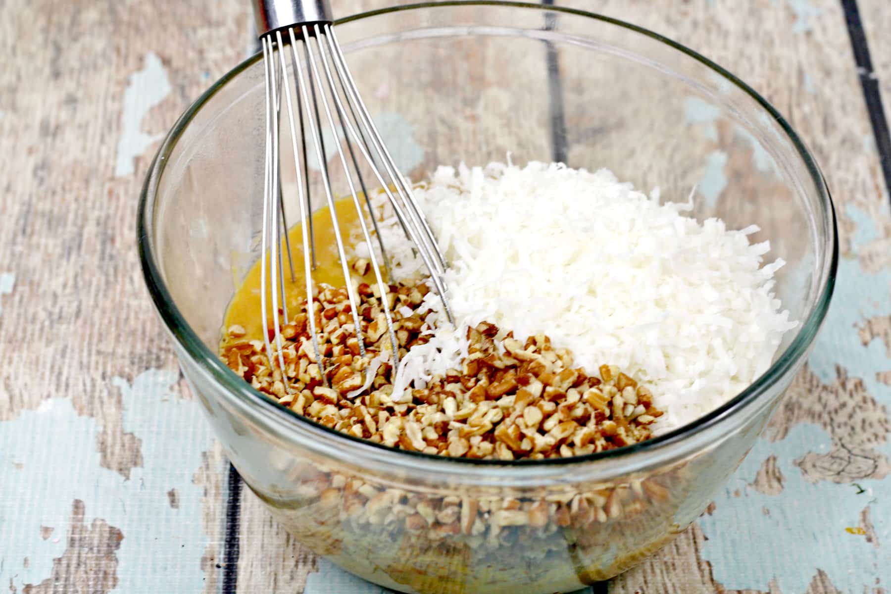 Next step in making German Chocolate Brownies is to stir in shredded coconut, vanilla, and chopped pecans, then set it aside to cool.
