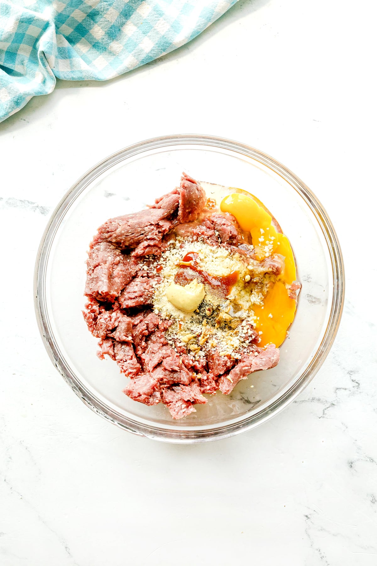 First step in preparing Crockpot Salisbury Steak is to combine ground beef, breadcrumbs, eggs, Worcestershire sauce, ketchup, Dijon mustard, garlic powder, onion powder, salt, and pepper to a large bowl.