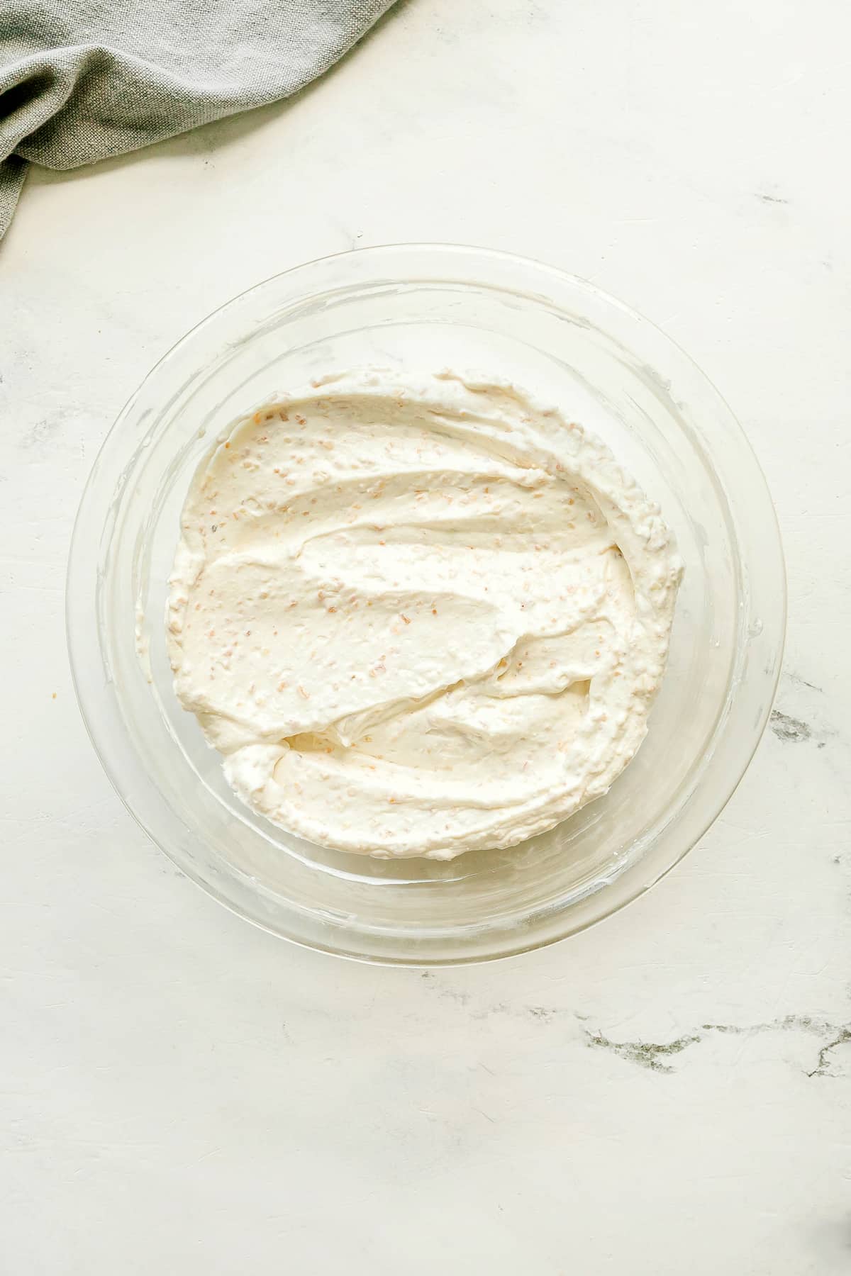 Next step in preparing French Onion Dip is to mix well the ingredients. A gray cloth is partially visible in the corner.